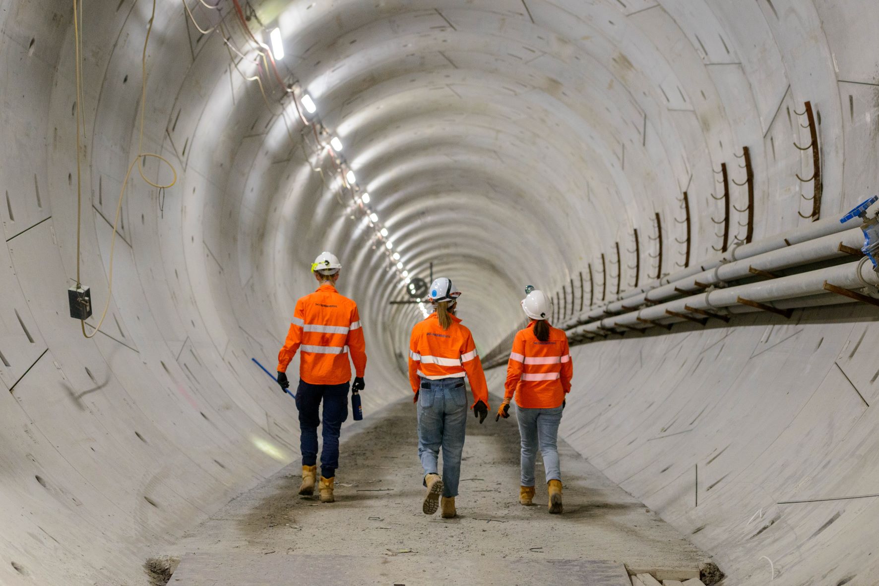 People in high-vis workwear as they walk through a tunnel.