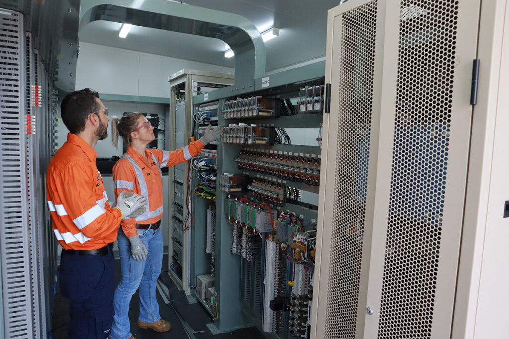 Engineers examining installed technology at hut.