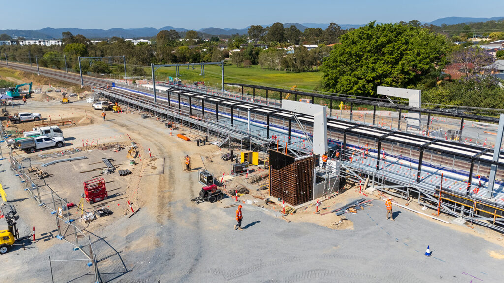 Drone shot of Merrimac station platform, lift shafts and pedestrian overpass support structures taking shape.